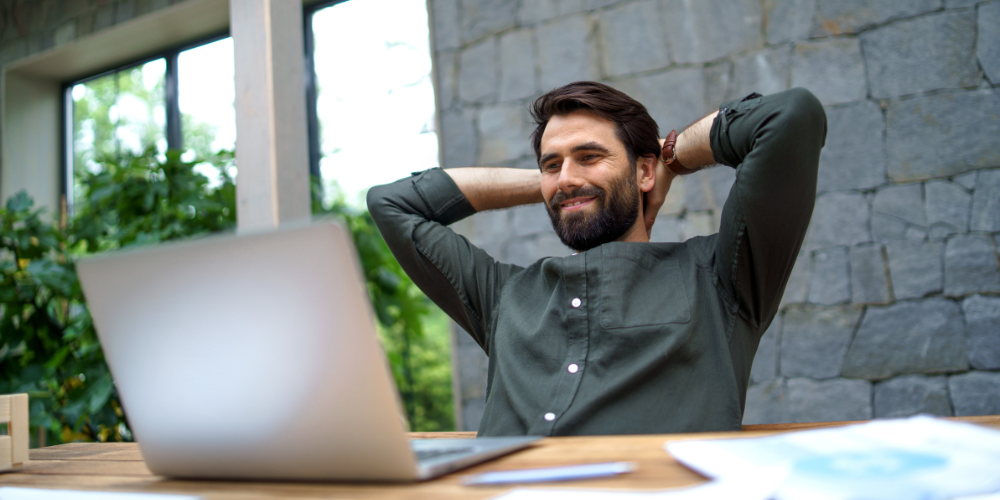 Satisfied guy looking at his laptop, just closed a sale